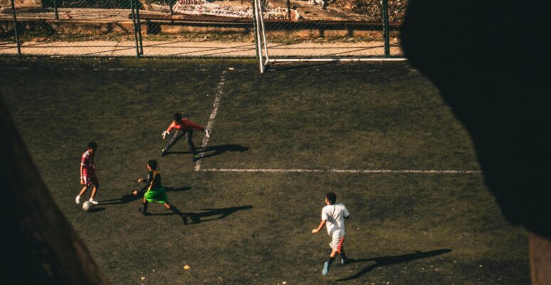 kinderen spelen voetbal op gras met goal