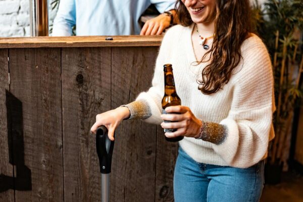 Vrouw wat een bierflesje vasthoudt in gezellige setting