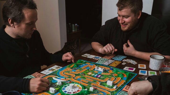 Twee mannen spelen bordspel met kaarten en geld, laat zien hoe bordspellen volwassenen verbinden